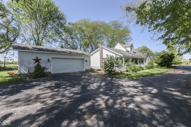 4462 S Morgantown Rd, Greenwood, IN 46143 - view of property exterior featuring driveway, a garage, an outdoor structure, and a porch