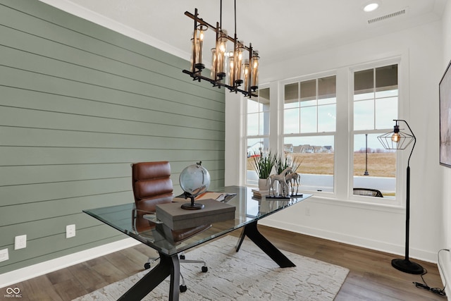 office with an inviting chandelier, wood-type flooring, and wooden walls