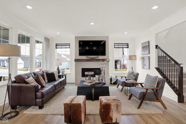 living room featuring ornamental molding, plenty of natural light, and light hardwood / wood-style flooring