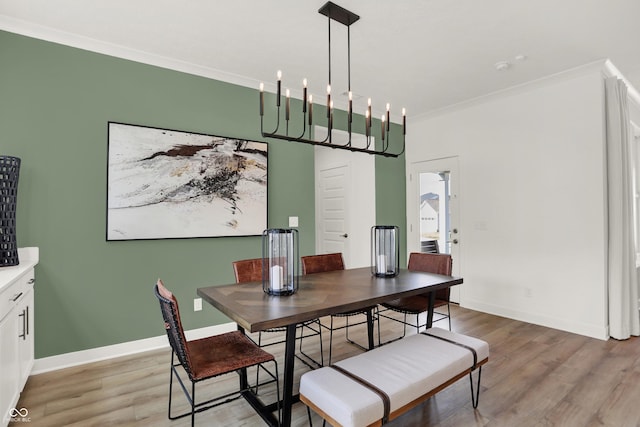 dining area with ornamental molding and light wood-type flooring