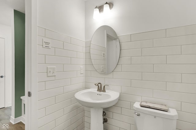 bathroom featuring tile walls, sink, hardwood / wood-style flooring, and toilet