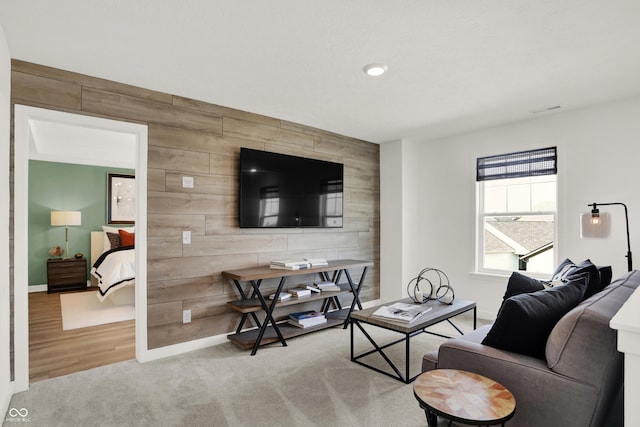 living room with carpet flooring and wood walls