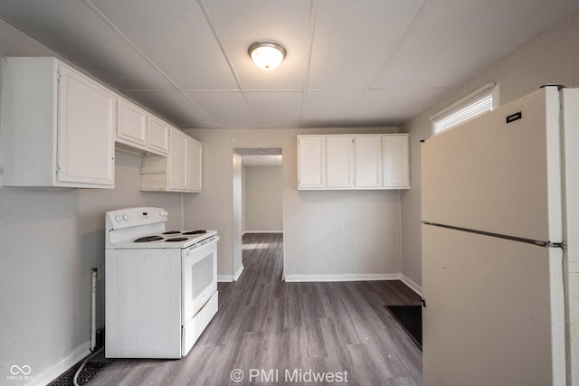 kitchen with white appliances, a drop ceiling, light wood-type flooring, and white cabinets