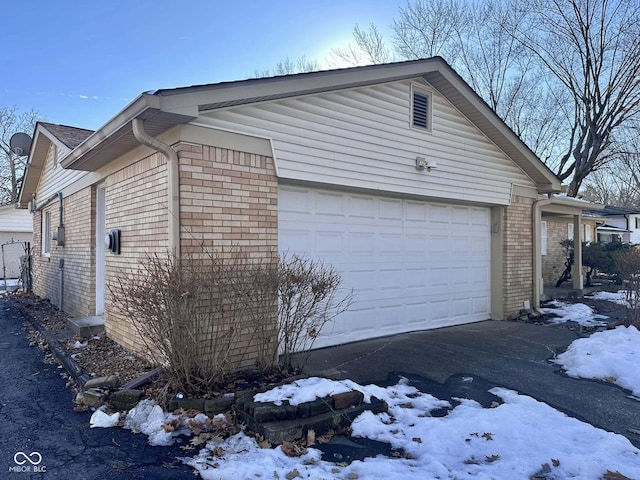 view of snow covered exterior featuring a garage