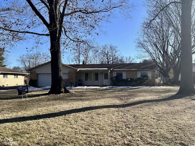 ranch-style home featuring a garage and a front lawn