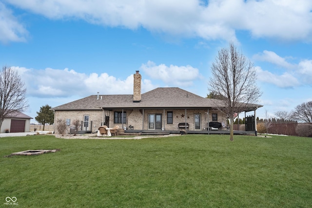 back of house featuring a patio, a lawn, and an outdoor fire pit