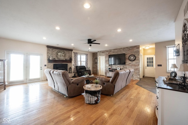 living room with light hardwood / wood-style flooring, a fireplace, and ceiling fan