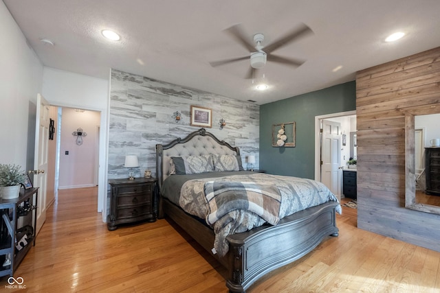 bedroom with connected bathroom, ceiling fan, and light wood-type flooring