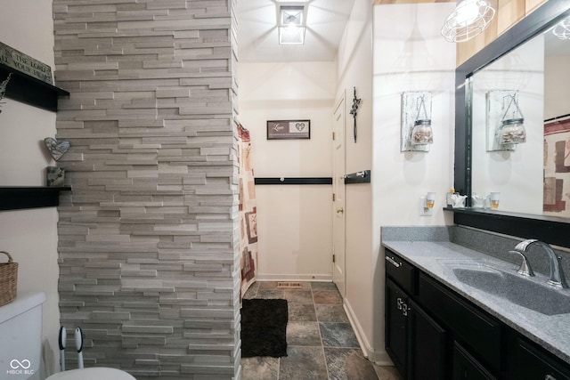 bathroom with walk in shower, vanity, and toilet