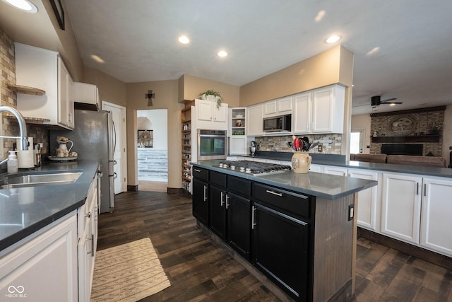 kitchen with sink, white cabinetry, dark hardwood / wood-style floors, a kitchen island, and stainless steel appliances