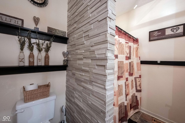 bathroom featuring a shower with curtain and toilet