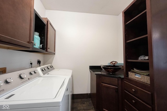 washroom with dark hardwood / wood-style flooring, washing machine and dryer, and cabinets