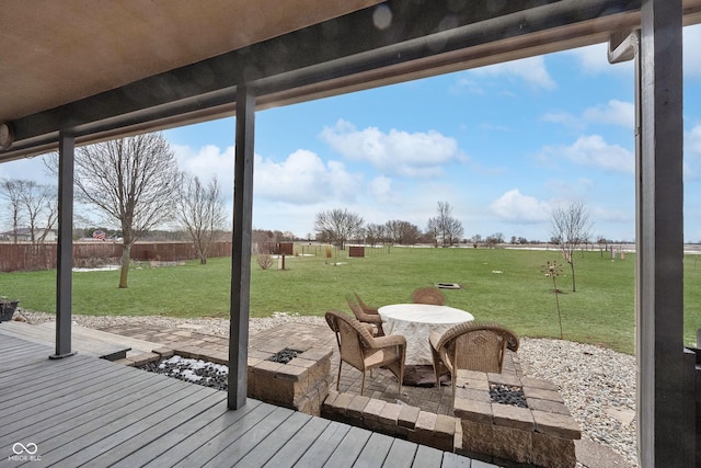 wooden deck with a fire pit, a lawn, and a patio area