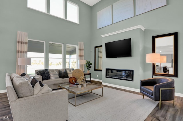 living room featuring hardwood / wood-style flooring and a towering ceiling