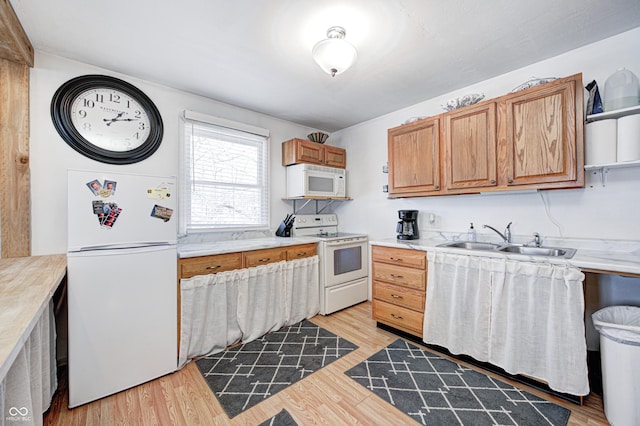 kitchen featuring sink, white appliances, and light hardwood / wood-style flooring