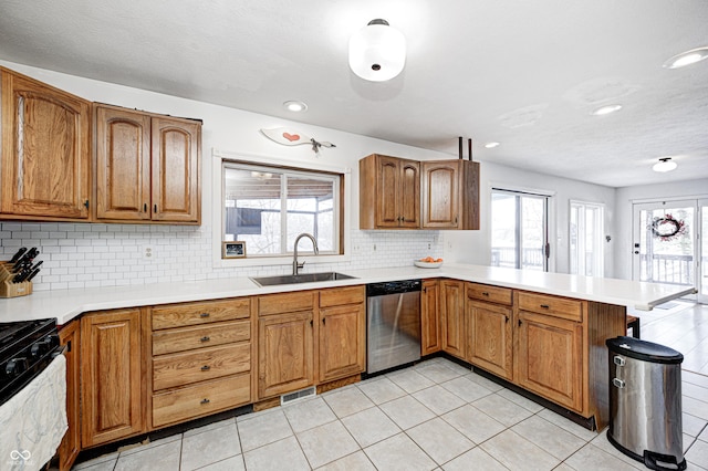 kitchen featuring sink, tasteful backsplash, stainless steel dishwasher, black range with gas stovetop, and kitchen peninsula