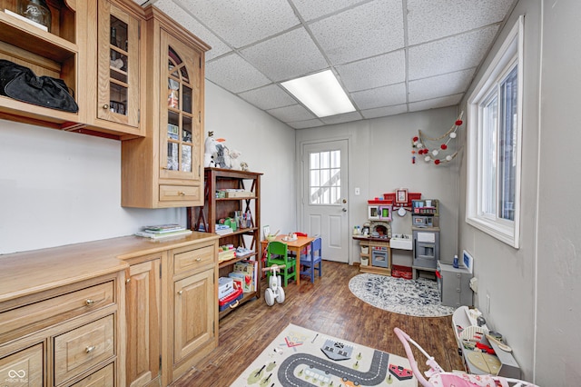 game room with a drop ceiling and dark hardwood / wood-style floors