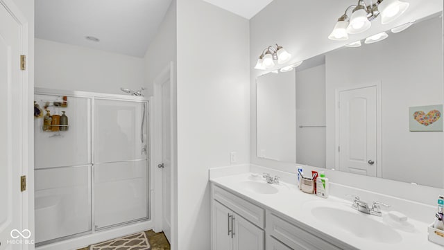 bathroom featuring a shower with door, vanity, and an inviting chandelier