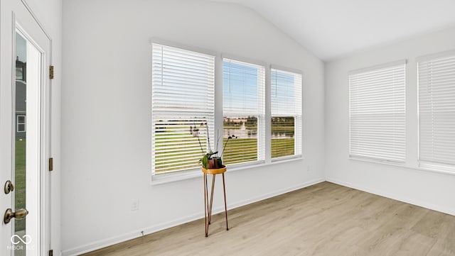 unfurnished room featuring vaulted ceiling and light wood-type flooring