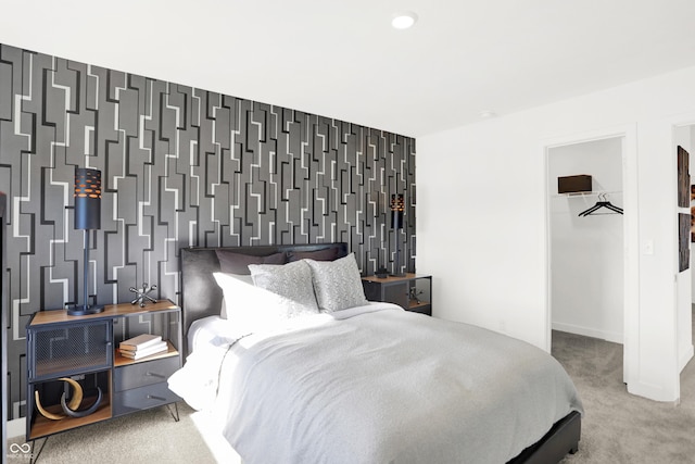 carpeted bedroom with a walk in closet