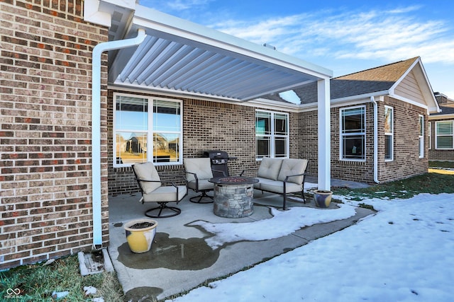 snow covered patio featuring grilling area and a fire pit