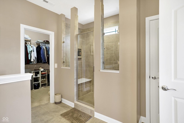 bathroom featuring a shower with shower door and tile patterned flooring