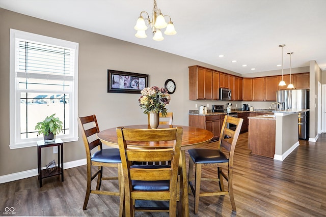 dining space with dark hardwood / wood-style flooring, sink, and a notable chandelier