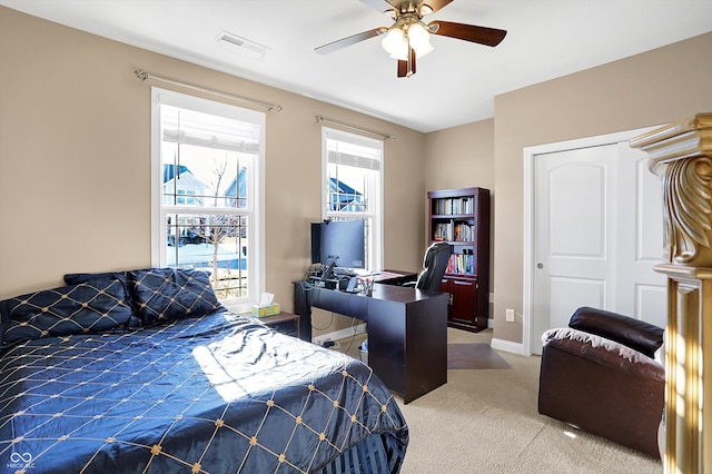 carpeted bedroom with ceiling fan and a closet