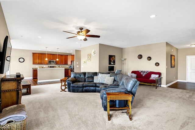 carpeted living room with ceiling fan