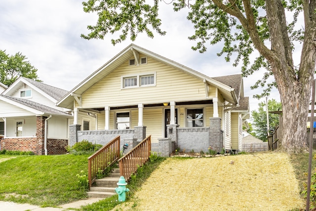 craftsman house featuring a porch and a front lawn