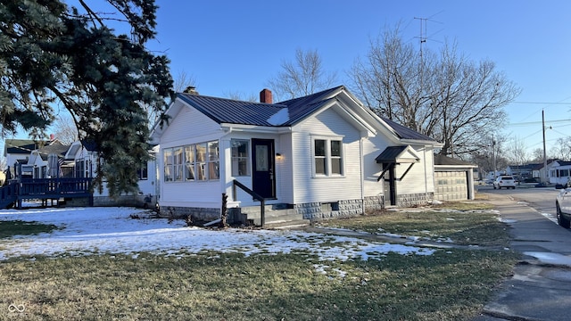 view of snow covered exterior with a garage and a lawn