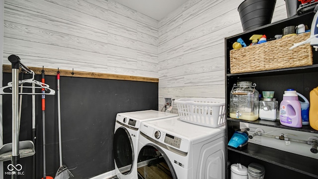 laundry room featuring washing machine and dryer and wooden walls