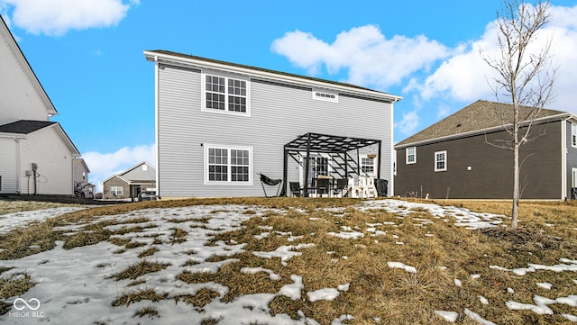 snow covered rear of property with a pergola