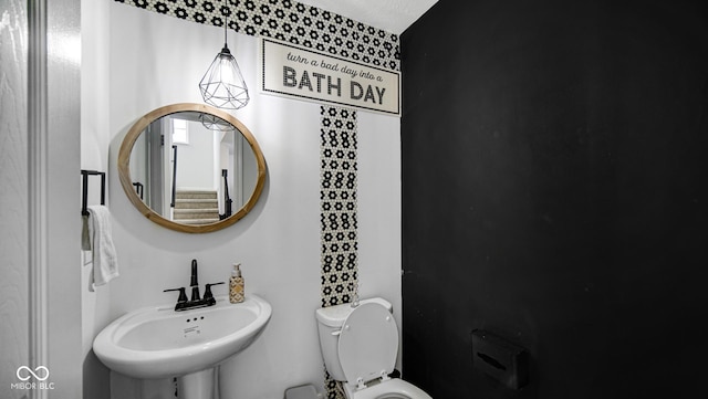 bathroom featuring sink, a textured ceiling, and toilet