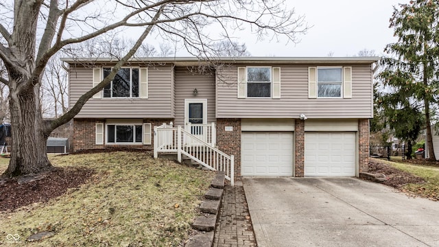 bi-level home featuring brick siding, an attached garage, and concrete driveway