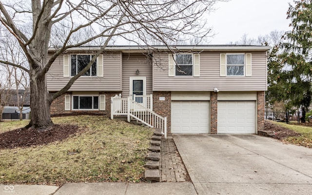 raised ranch featuring brick siding, concrete driveway, and an attached garage