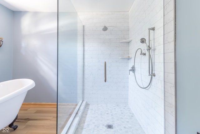 bathroom with hardwood / wood-style flooring and independent shower and bath