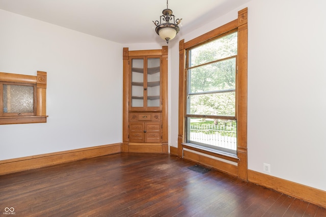 unfurnished room featuring dark hardwood / wood-style floors and a healthy amount of sunlight