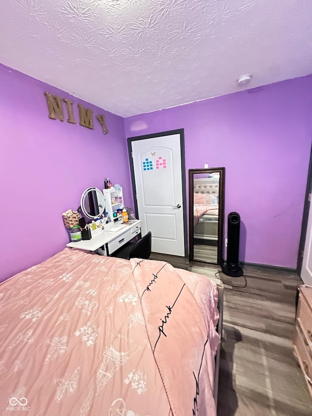 bedroom featuring wood-type flooring and a textured ceiling