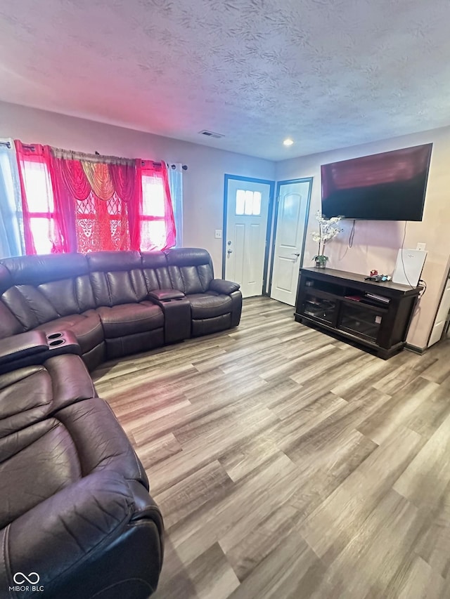 living room featuring a textured ceiling and light wood-type flooring