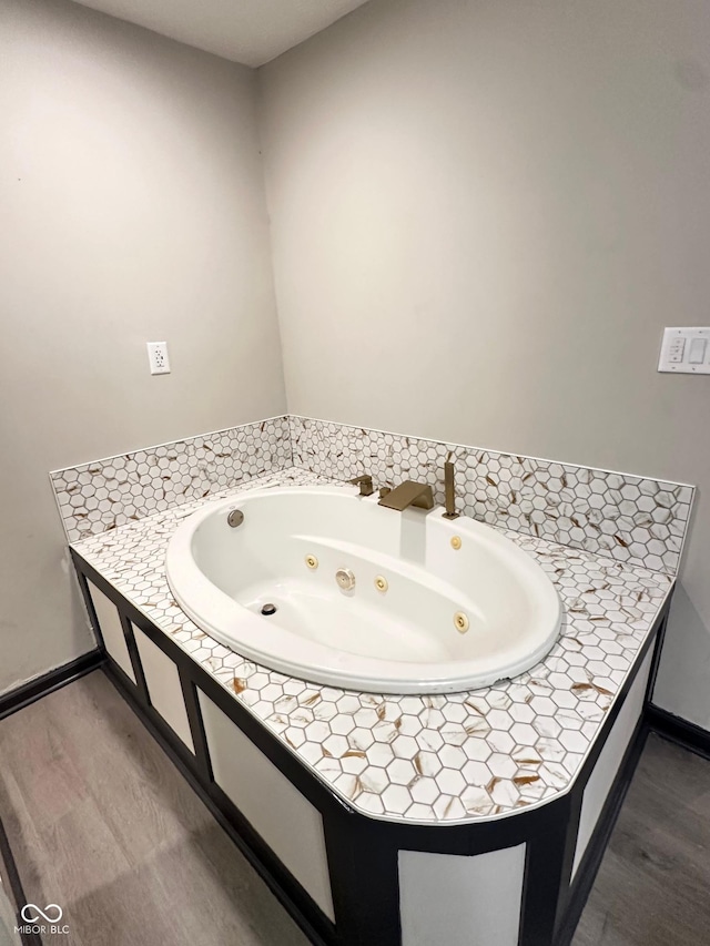 bathroom with wood-type flooring and a tub