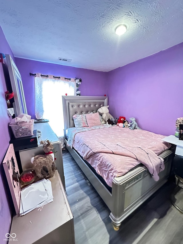 bedroom featuring dark hardwood / wood-style floors and a textured ceiling