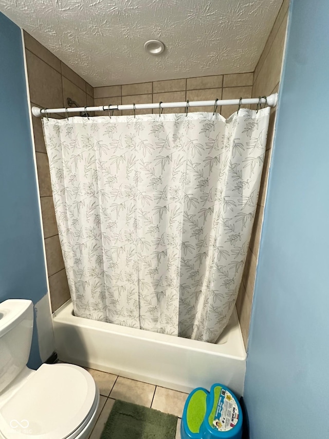 bathroom with tile patterned flooring, a textured ceiling, and toilet