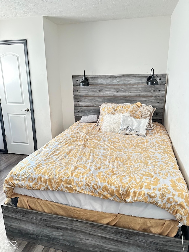 bedroom with dark wood-type flooring and a textured ceiling