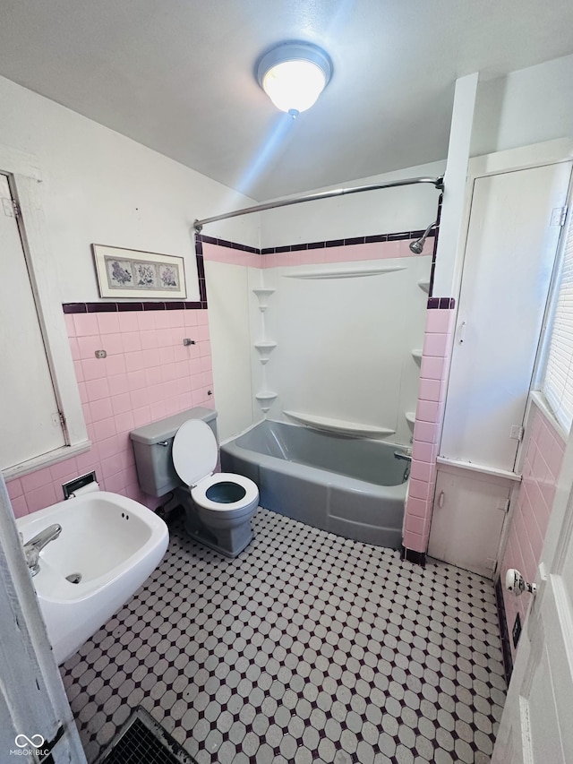 bathroom with shower / washtub combination, tile walls, and toilet