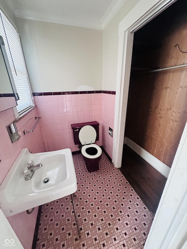 bathroom featuring sink, tile walls, toilet, crown molding, and tile patterned floors