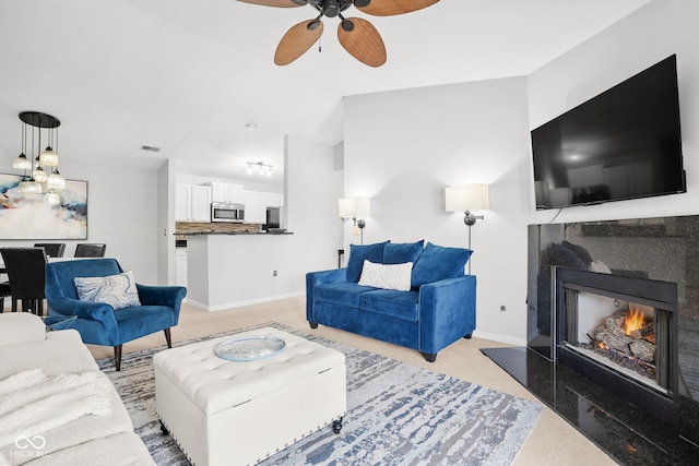 carpeted living room featuring a tile fireplace and ceiling fan