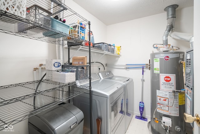 laundry area with washer and dryer, water heater, and a textured ceiling