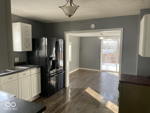 kitchen featuring sink, dark wood-type flooring, white cabinetry, a textured ceiling, and black fridge with ice dispenser