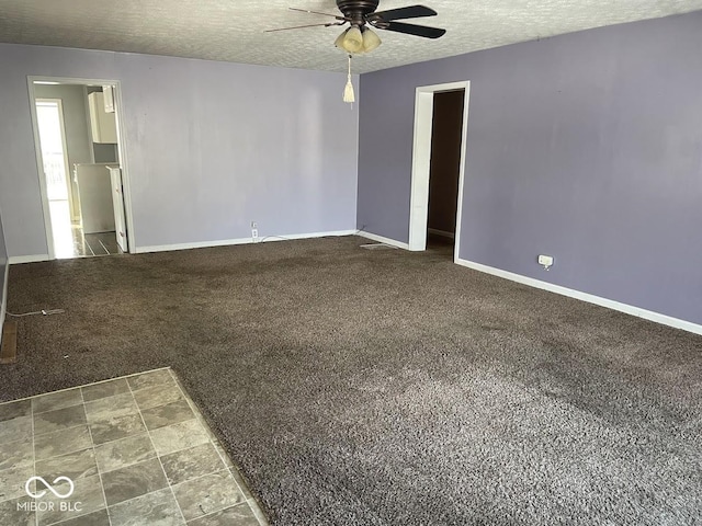 carpeted empty room with ceiling fan and a textured ceiling